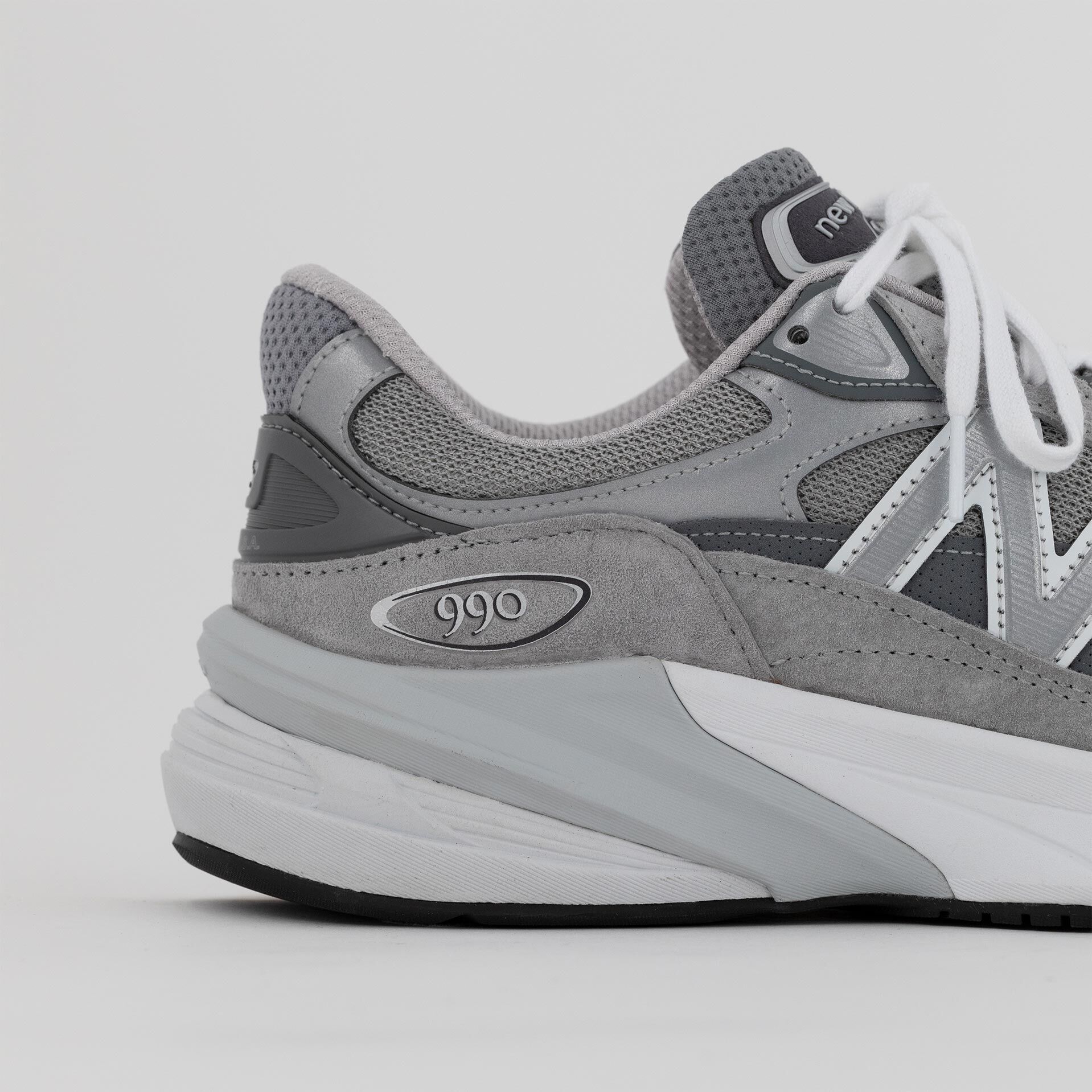 Close up detail of the heel and upper of a grey MADE in USA 990v6 showcasing the material and craftsmanship.